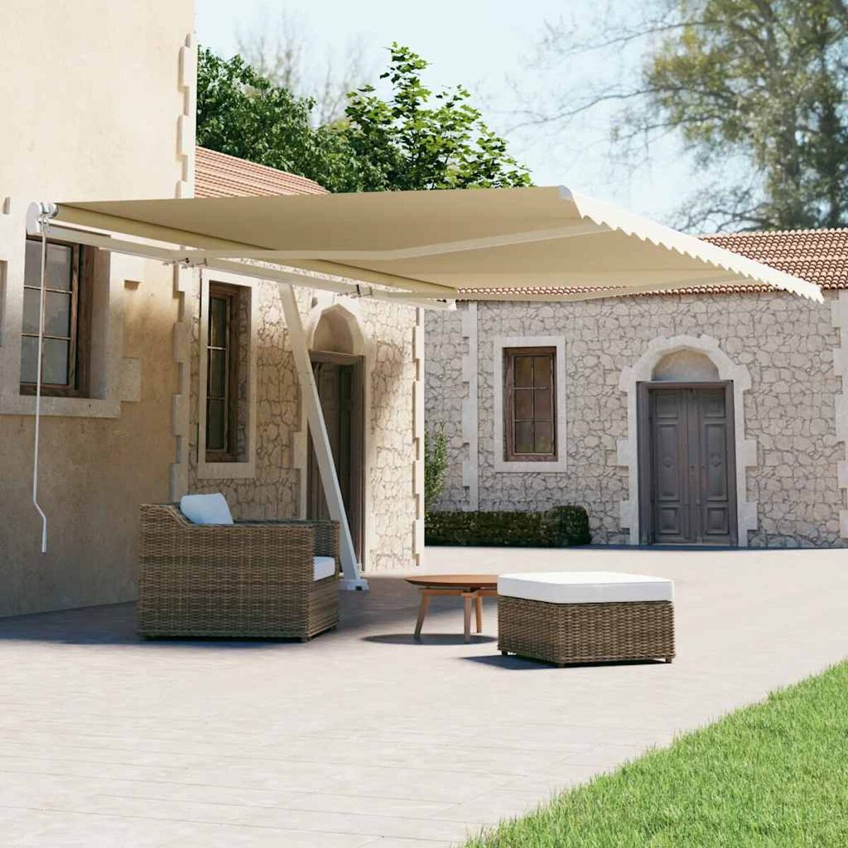 Beige Markise erstreckt sich über Terrasse mit Möbeln. Steingebäude im Hintergrund mit grünen Bäumen.