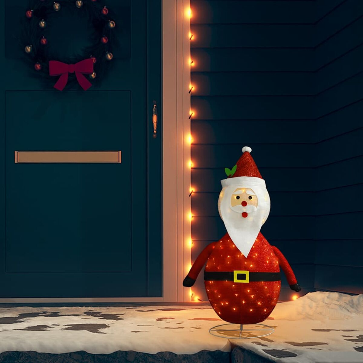 Eine Weihnachtsmann-Dekoration mit Lichtern. Sie steht auf einer schneebedeckten Oberfläche.
