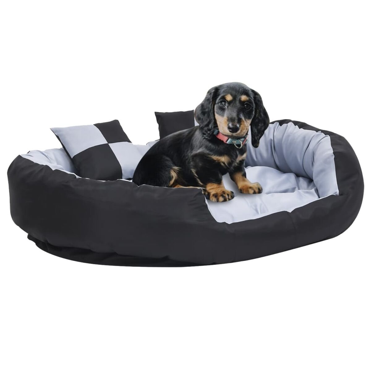 Ein kleiner Dackelwelpe in einem Hundebett, mit schwarz-weißen Kissen.