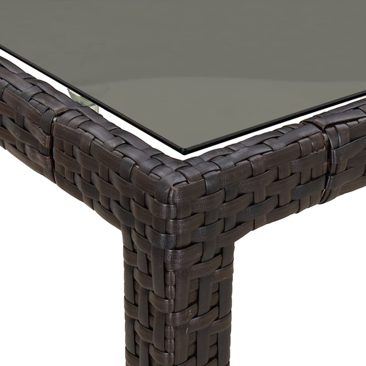 Nahaufnahme eines braunen Rattan-Tisches mit Glasplatte, Ecke.