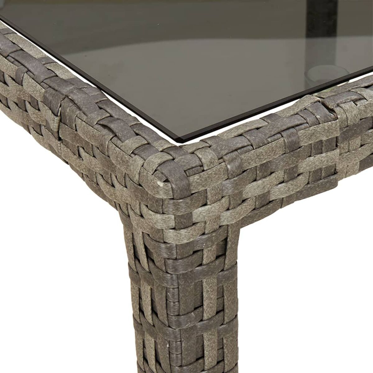 Nahaufnahme einer Korbtischecke. Graues gewebtes Material und eine dunkle Glasplatte.