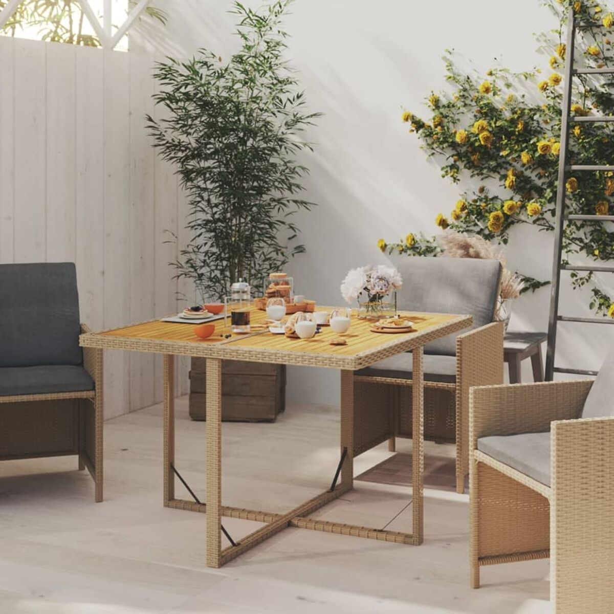Ein Tisch für eine Mahlzeit gedeckt. Enthält Blumen, Essen und Getränke, mit Stühlen drumherum.