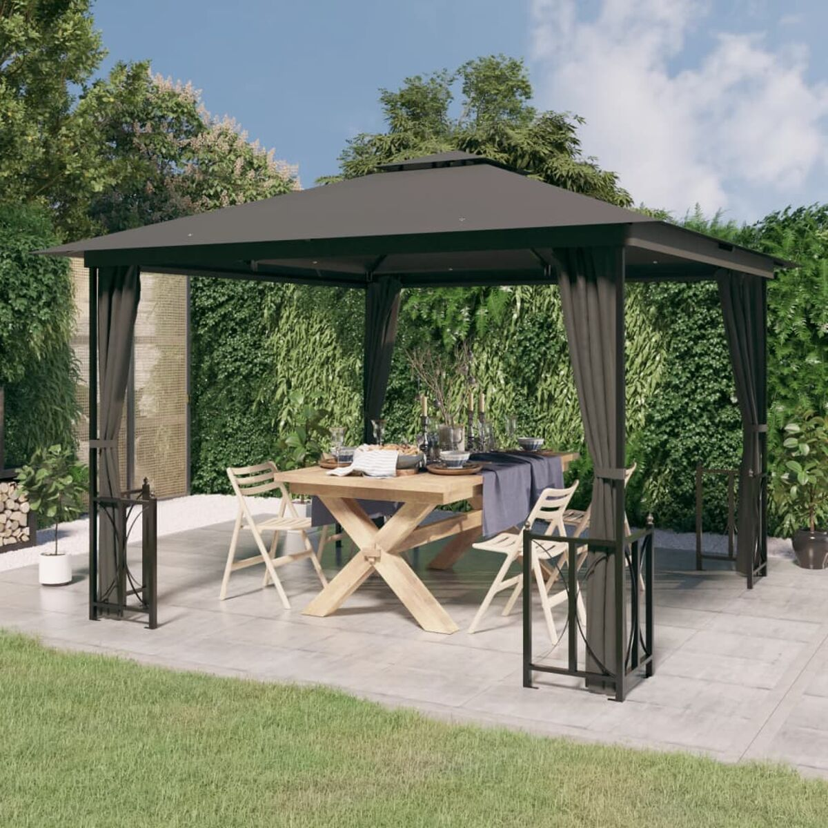 Pavillon mit Tisch und Stühlen auf einer Terrasse, umgeben von Grün. Graue Vorhänge hängen.