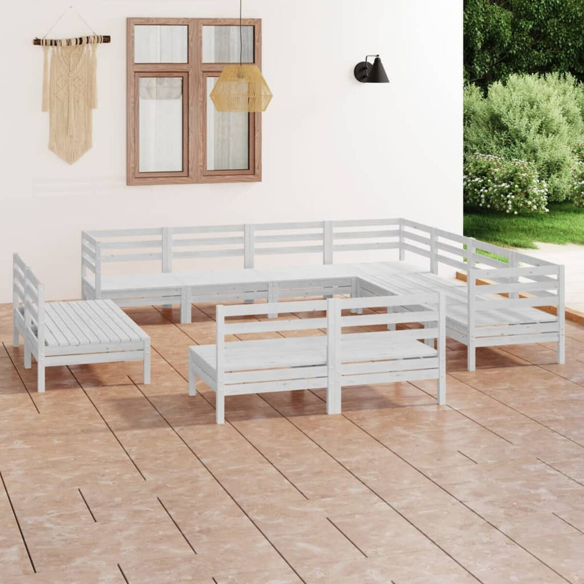 Weißes Holz-Terrassenmöbel-Set im U-Form. Im Hintergrund eine Wand mit Fenster.