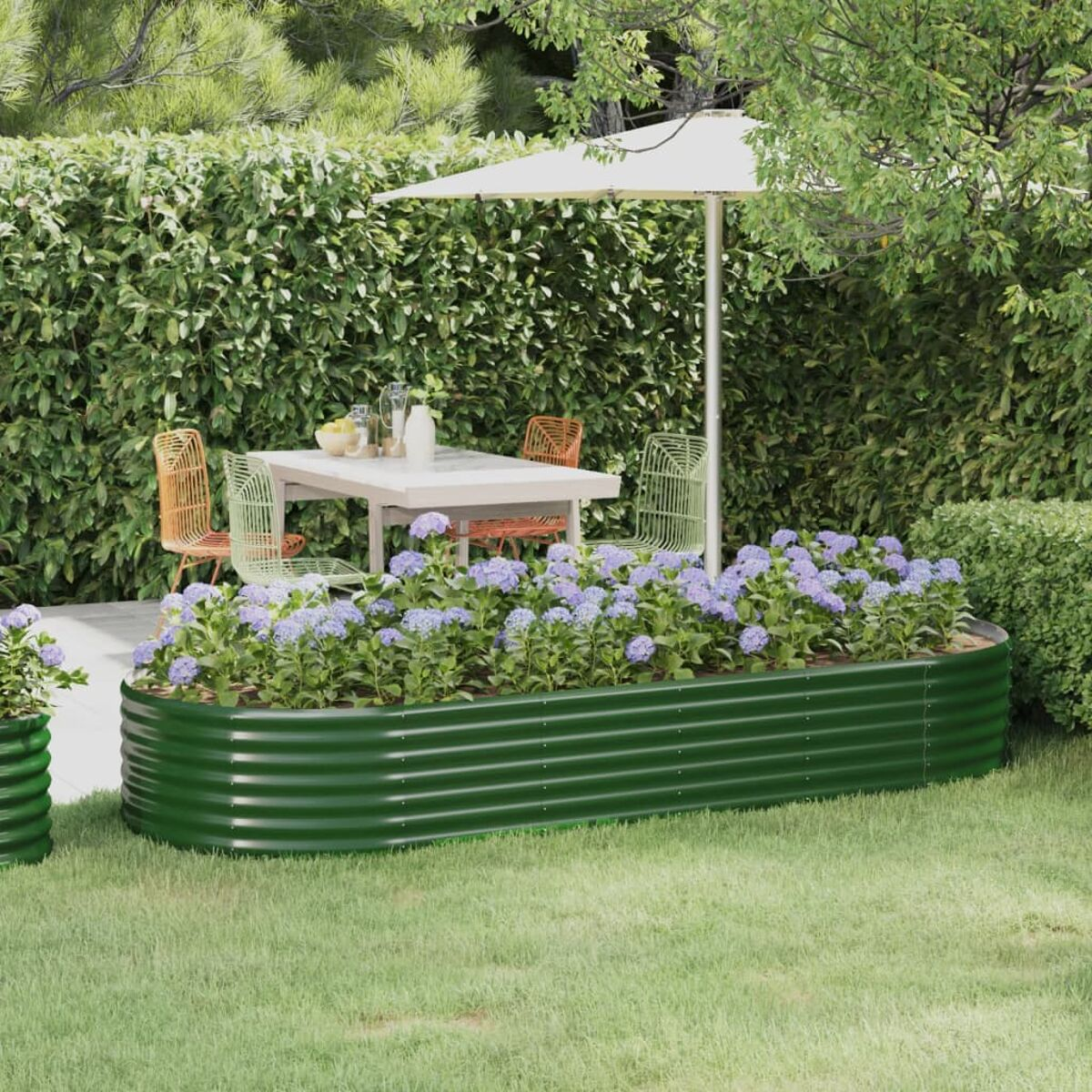 Gartenszene mit Blumenbeet, Tisch, Stühlen und Sonnenschirm. Grüne Pflanzen im Hintergrund.