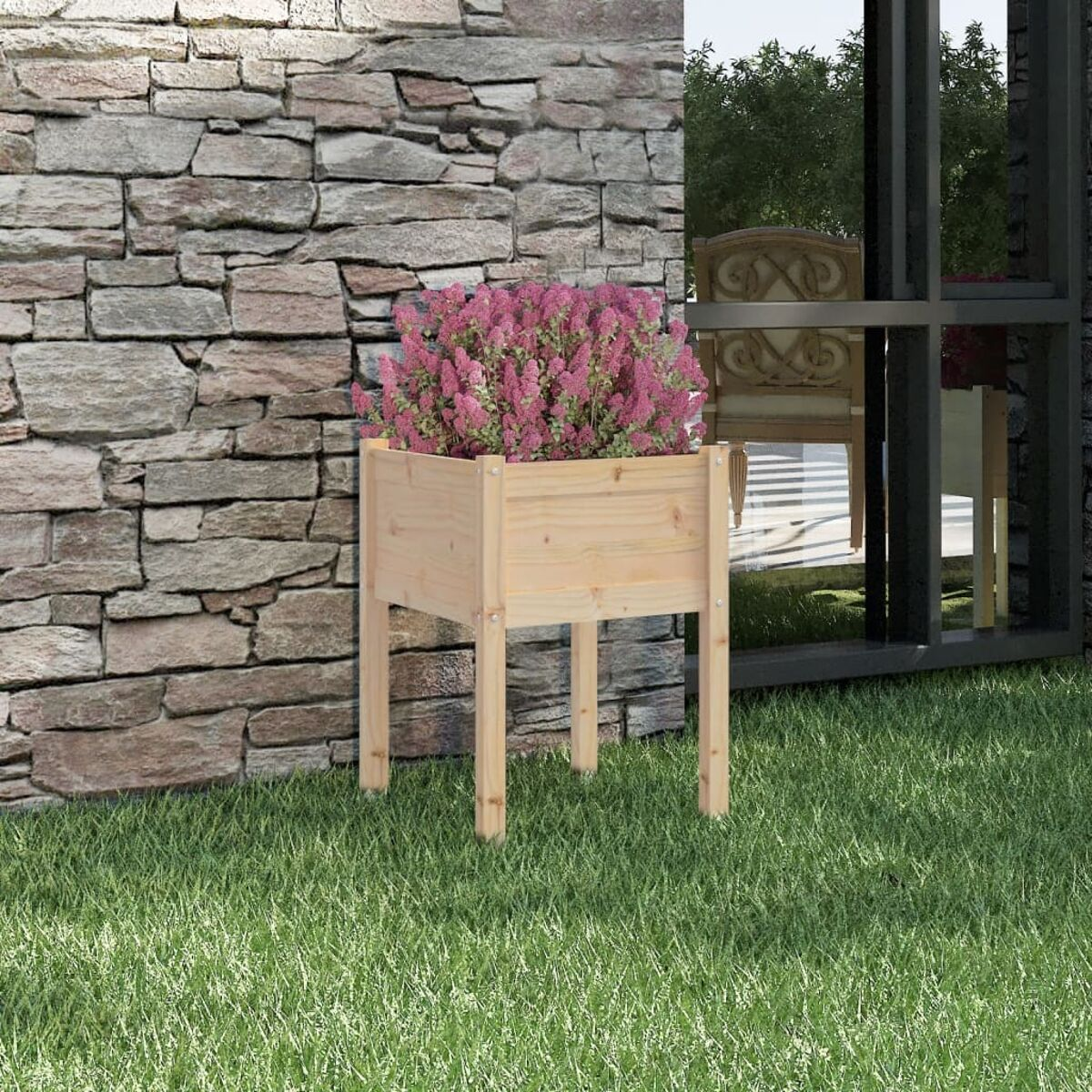 Holz-Pflanzkasten mit rosa Blumen. Auf grünem Gras, neben einer Steinmauer.