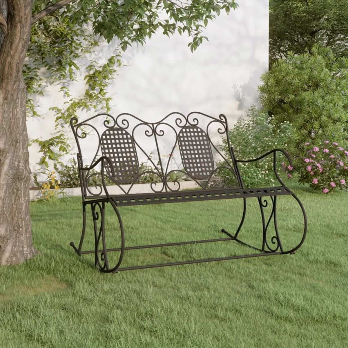 Schwarze Metall-Schaukelbank auf Gras. Verziertes Design mit dekorativen Mustern. Grüner Hintergrund.
