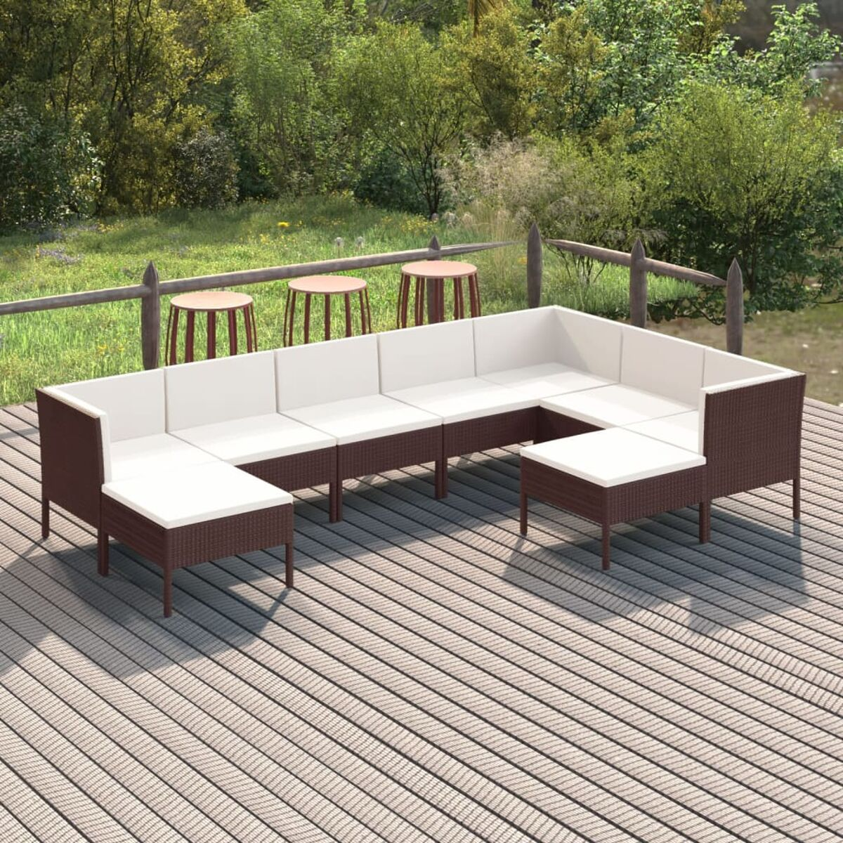 Ein braunes Outdoor-Ecksofa aus Korbgeflecht mit weißen Kissen.
