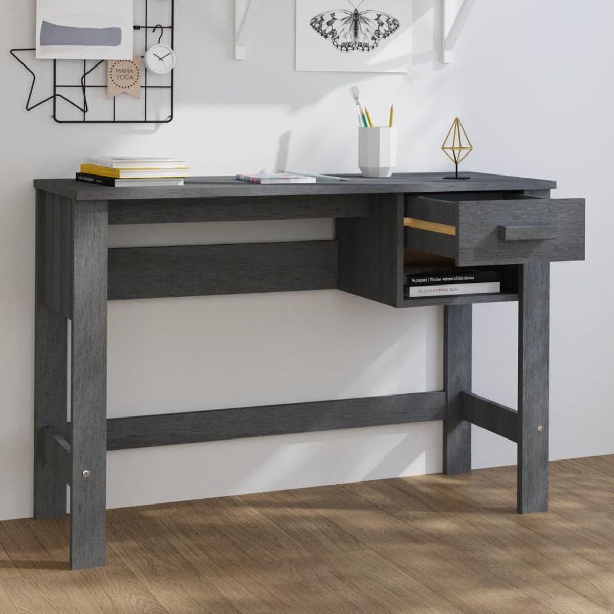Grauer Schreibtisch mit Schublade und offenem Regal. Bücher und Deko oben drauf.