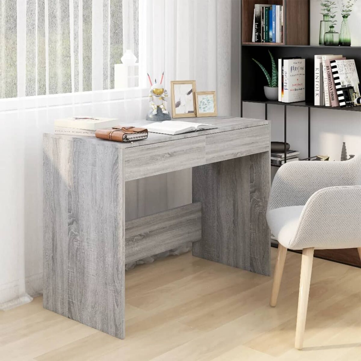 Holzschreibtisch mit Büchern, Bildern und einem Stuhl. Der Hintergrund ist weiß.