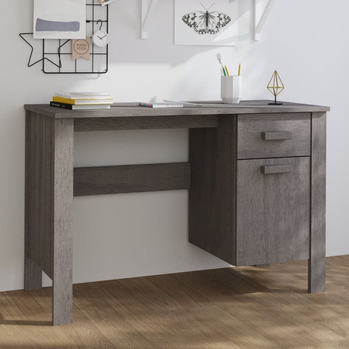 Ein grauer Holzschreibtisch mit Schublade und Schrank. Es gibt Gegenstände an der Wand und auf der Arbeitsfläche.