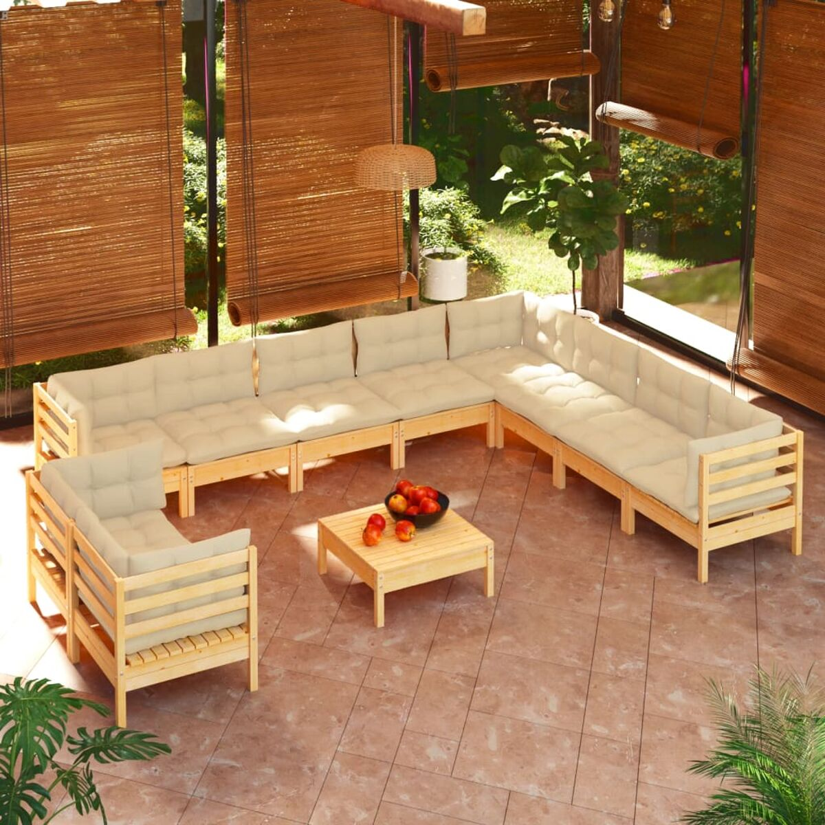 Outdoor-Ecksofa mit beigen Kissen und einem kleinen Holztisch mit Obst. Garten im Hintergrund.