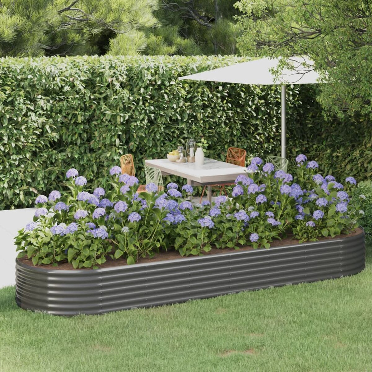Ein schwarzes Metall-Gartenbeet mit lila Blumen in einem Garten.