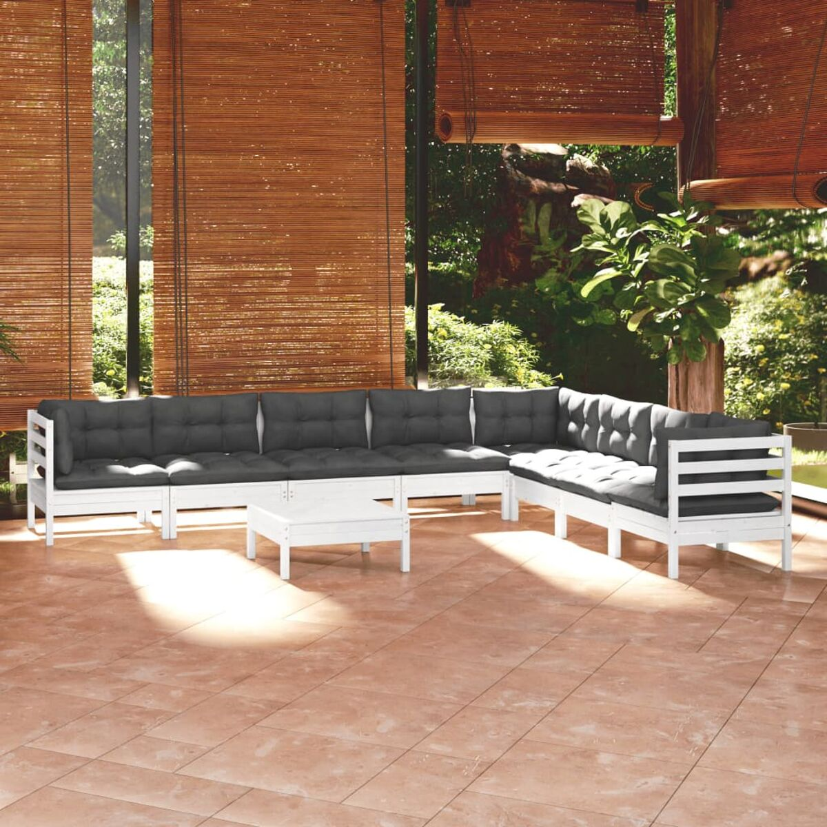 Weißes Outdoor-Ecksofa mit grauen Kissen und einem kleinen Tisch. Auf einem Fliesenboden.
