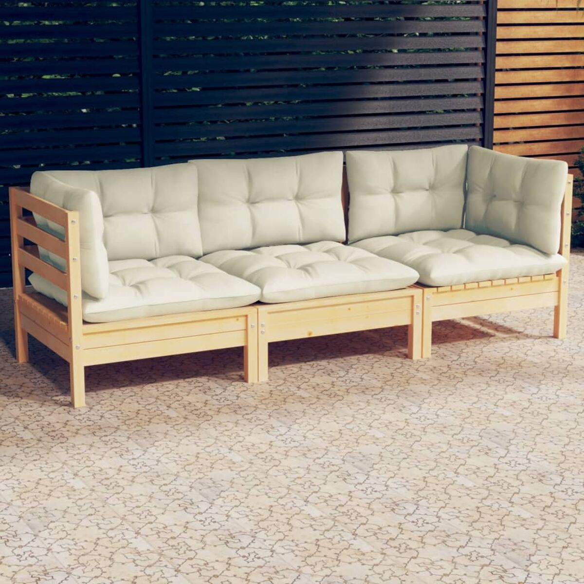 Holz-Outdoor-Sofa mit cremefarbenen Kissen. Auf einer gefliesten Terrasse. Hintergrund: schwarzer Lattenzaun.