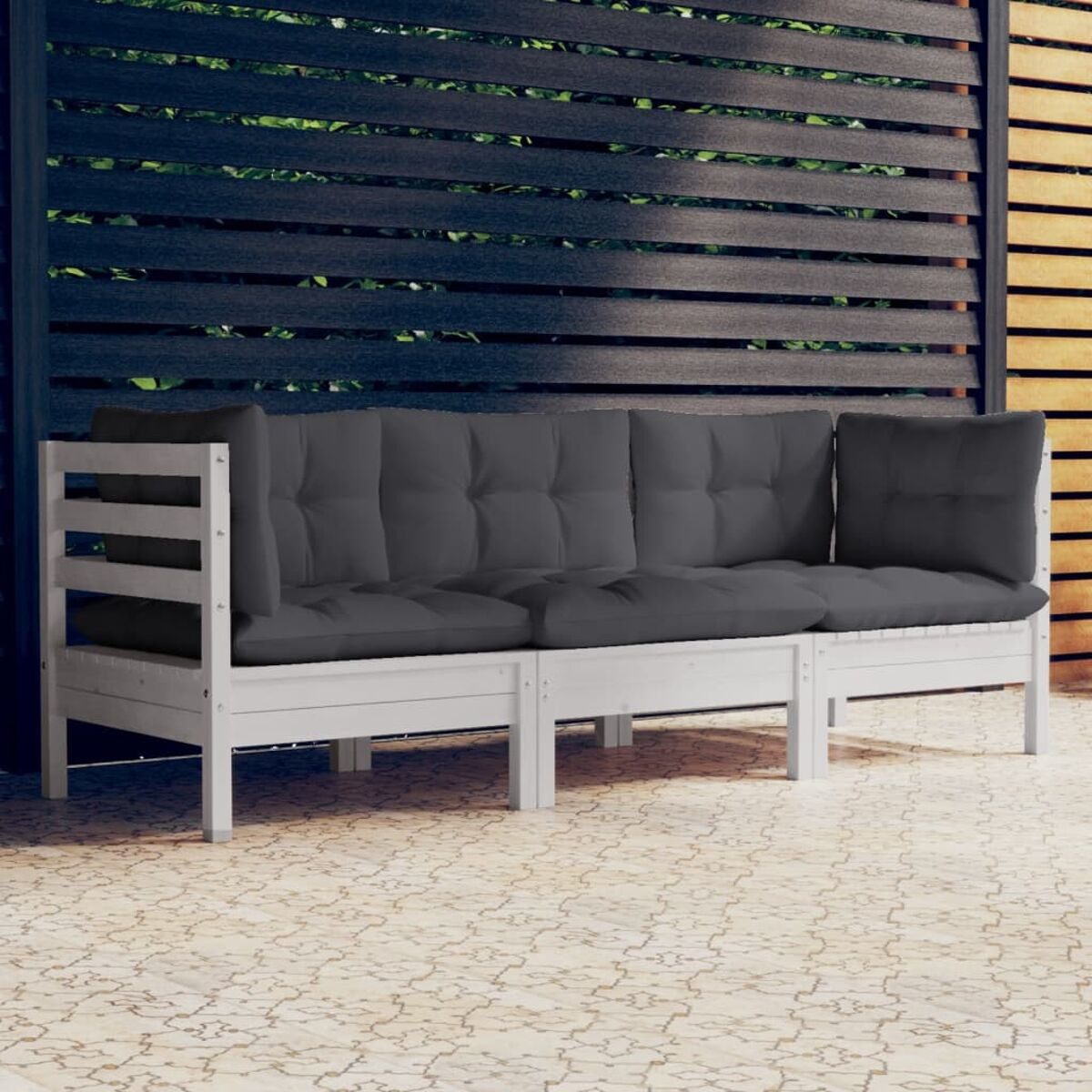 Weißes Holz-Außensofa mit grauen Kissen. Dunkler Holzzaun im Hintergrund.