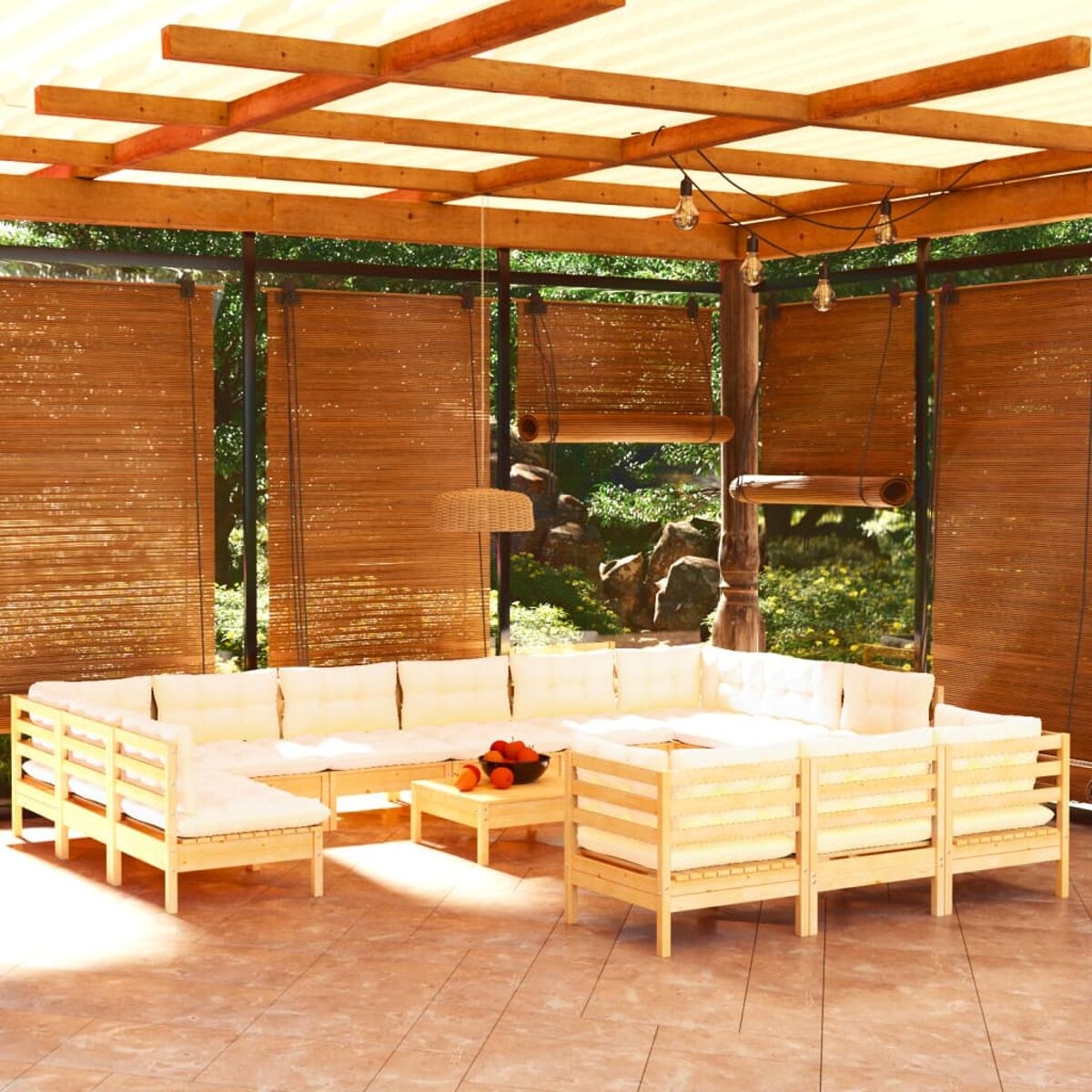 Holz-Gartenmöbel mit cremefarbenen Kissen, Tisch mit Orangen, unter Bambusjalousien und Holzbaldachin.