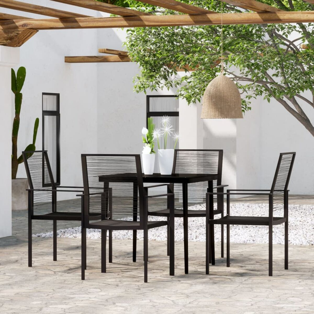 Schwarzes Esszimmer-Set im Freien. Tisch und Stühle auf Steinterrasse, unter Holzpergola.