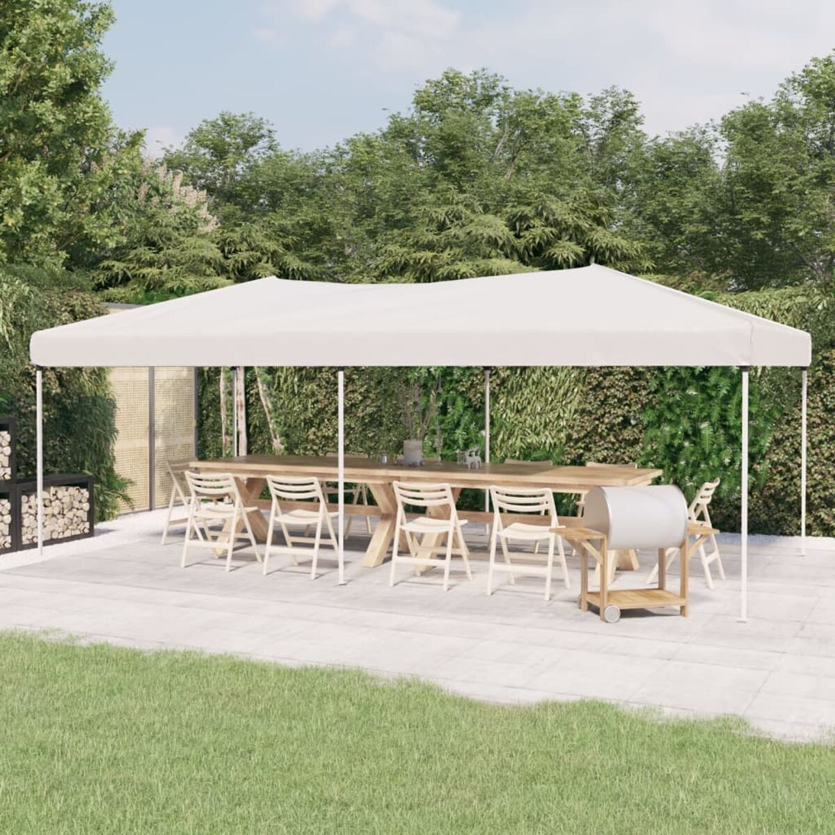 Ein Essbereich im Freien unter einem weißen Zelt. Tisch mit Stühlen, Grill und ein Holzstapel sind vorhanden.