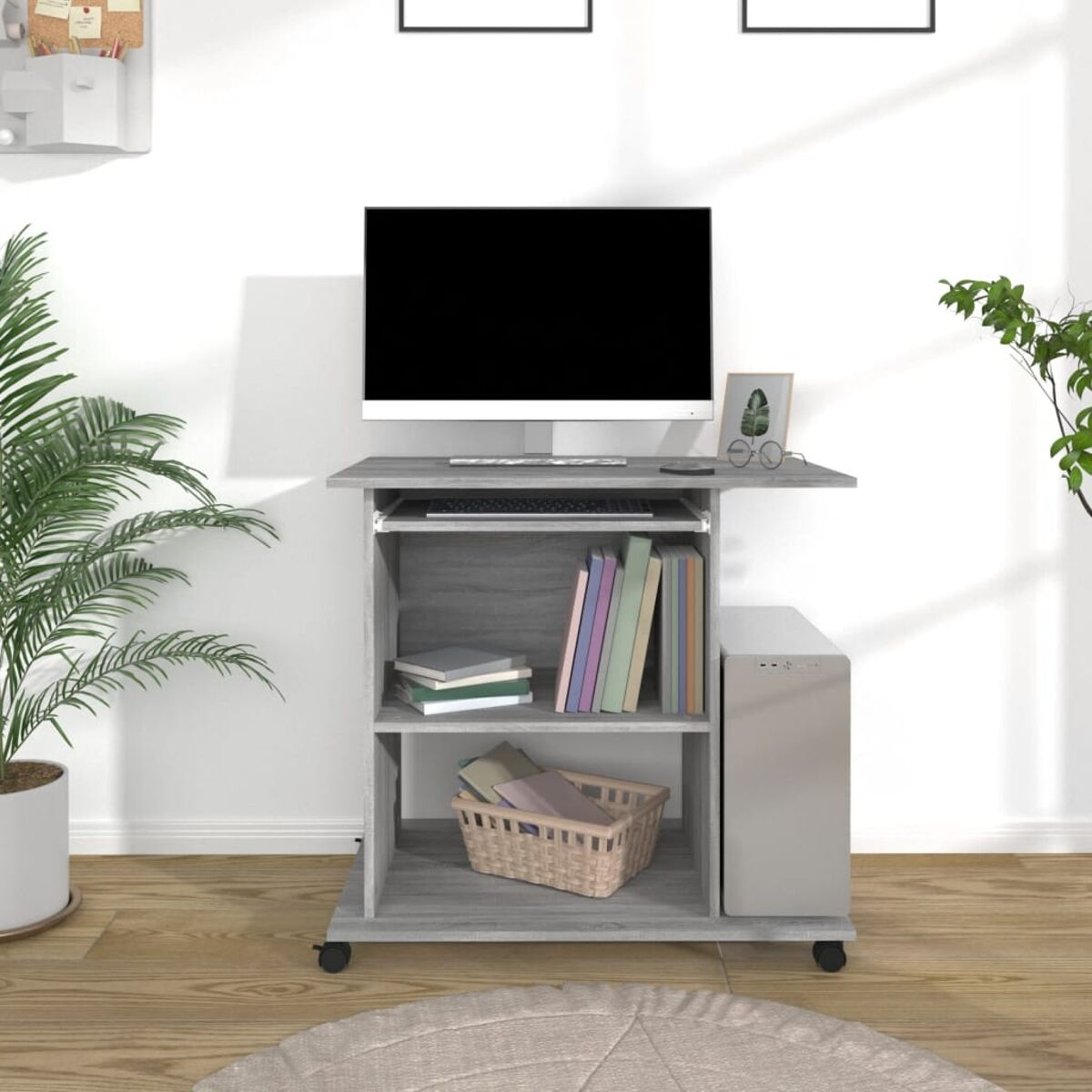Computertisch mit Monitor, Büchern und Computer.