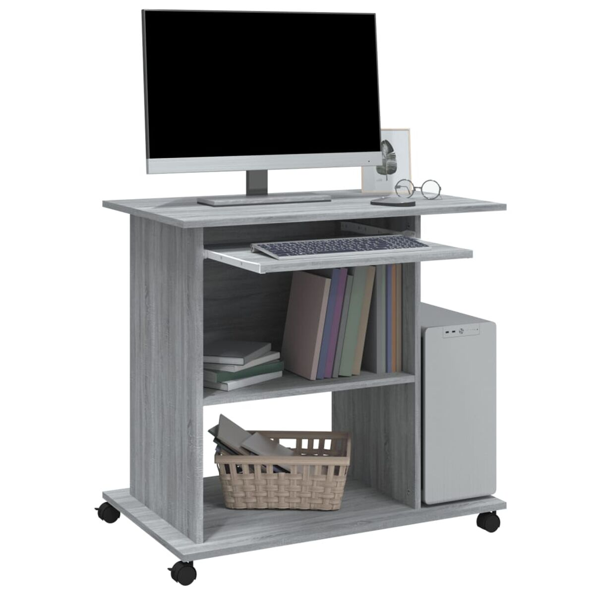 Computertisch mit Monitor, Tastatur, Büchern und einem Korb.