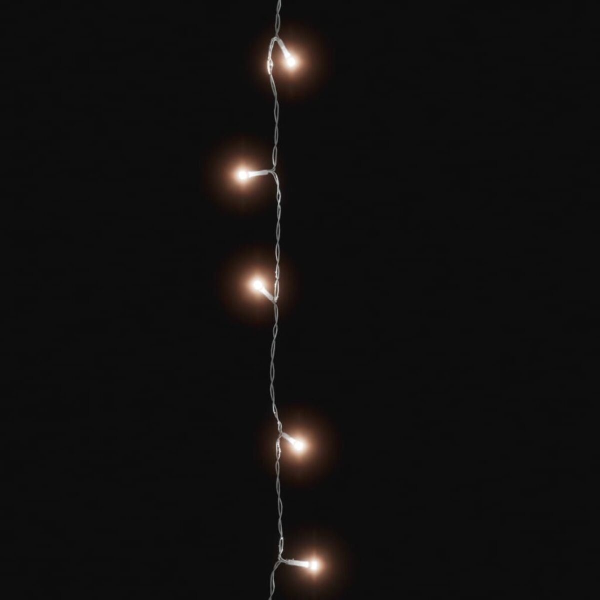 Lichterkette. Fünf sichtbare Lichter, die vor dunklem Hintergrund leuchten.