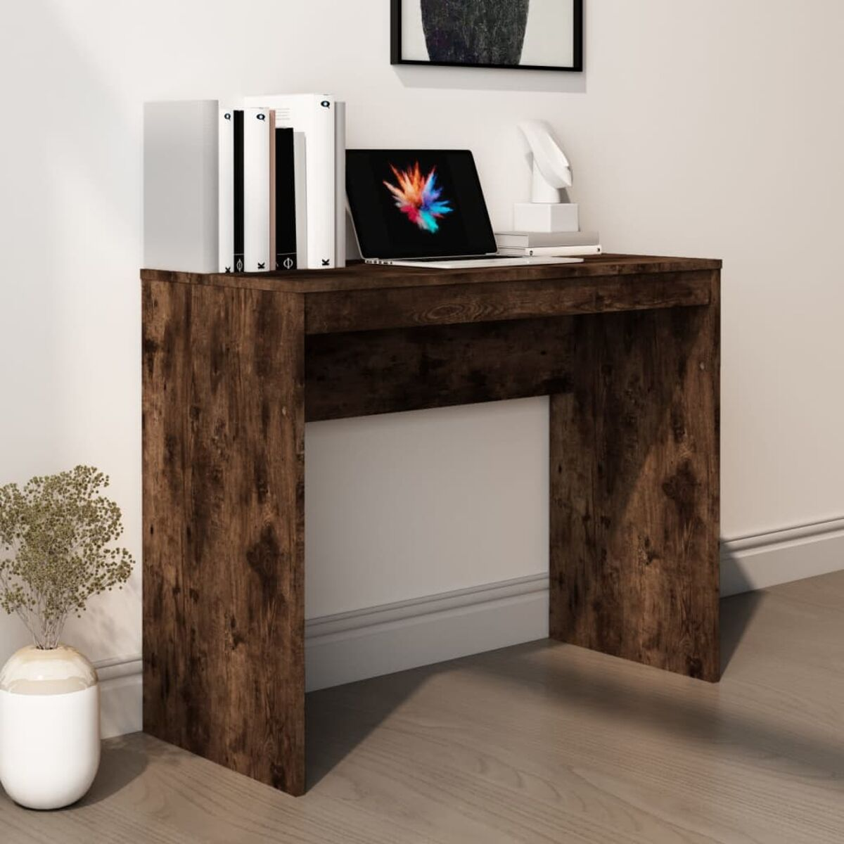 Holzschreibtisch mit Laptop, Büchern und einer Vase. Der Schreibtisch hat eine Holzstruktur und steht vor einer Wand.