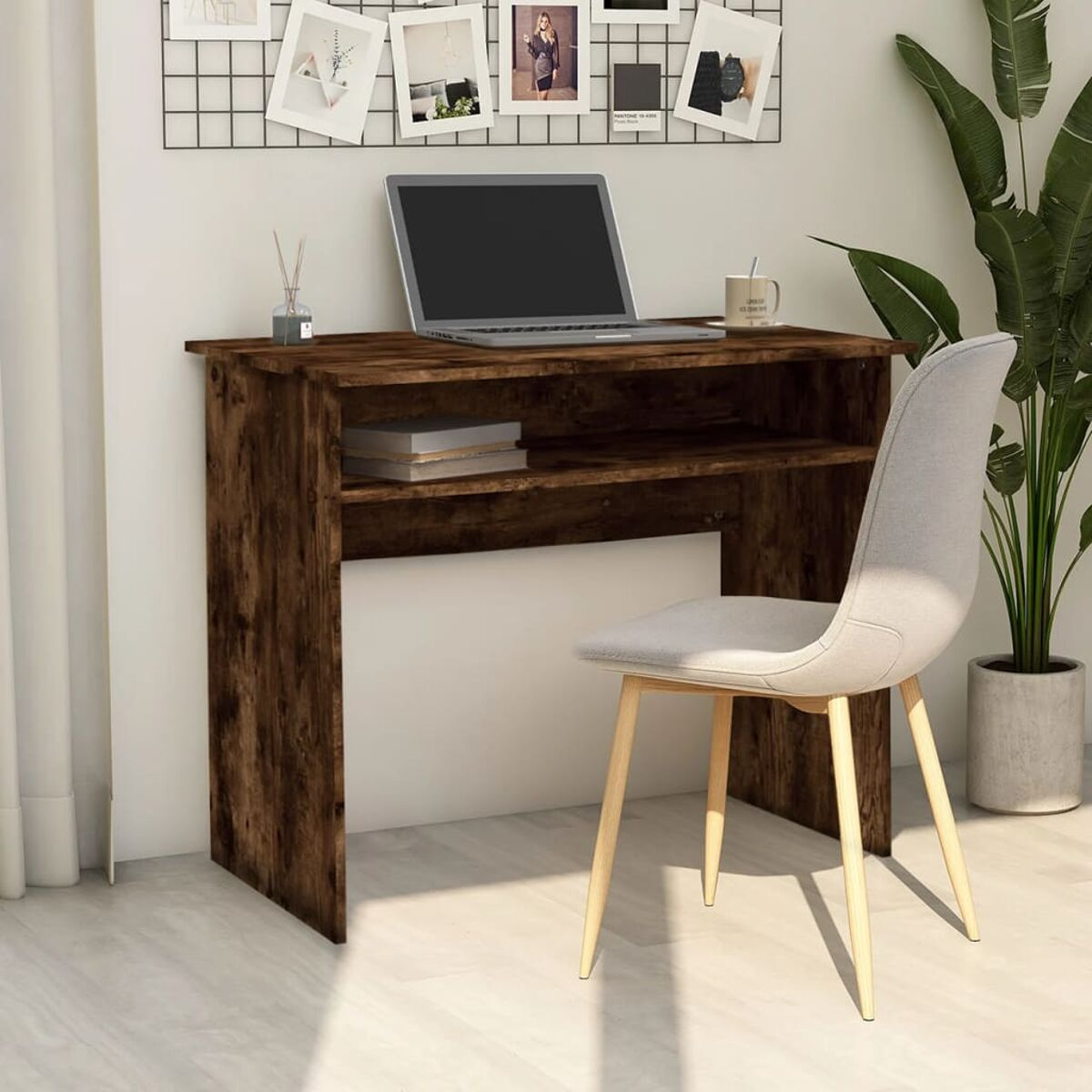 Ein Holzschreibtisch mit Laptop, Büchern und einem weißen Stuhl. Eine Pflanze im Hintergrund.