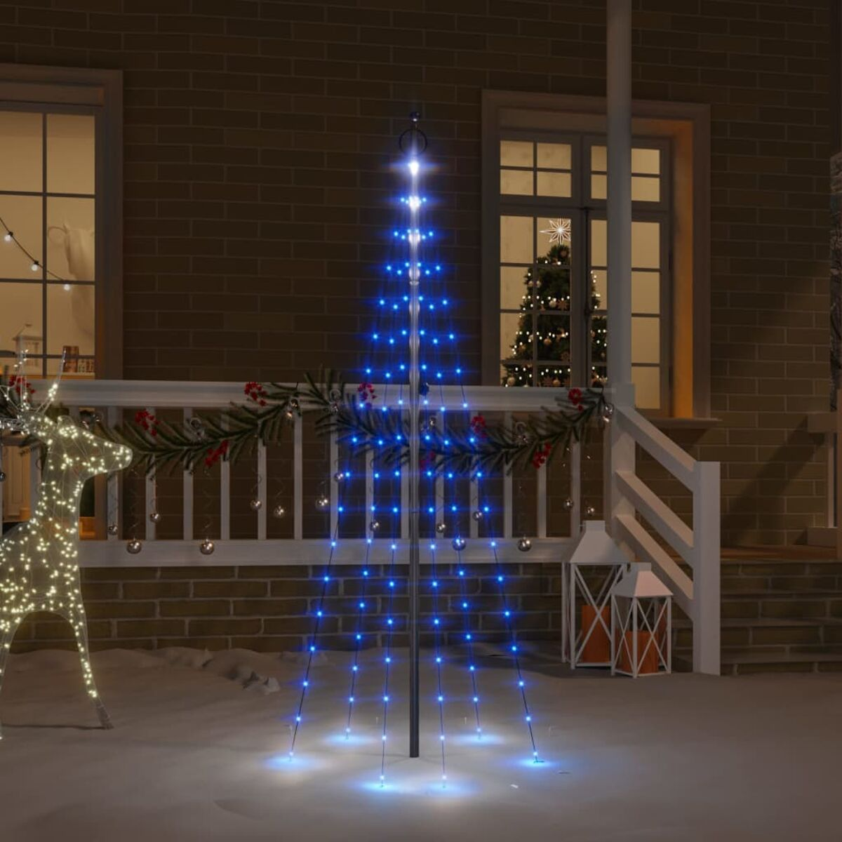 Weihnachtsbaum aus blauen Lichtern vor einem Haus bei Nacht.
