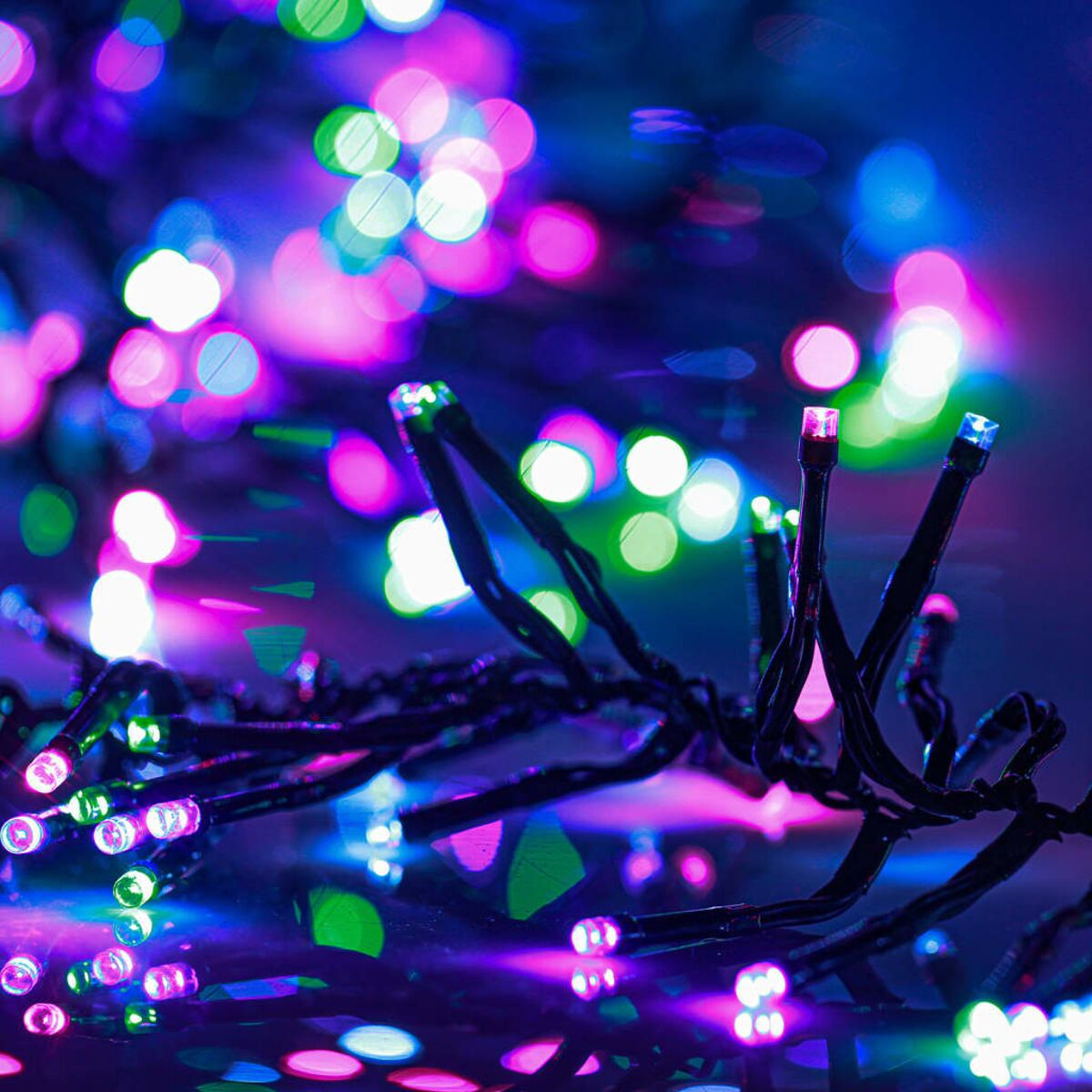 Nahaufnahme von bunten Weihnachtslichtern in unscharfer Umgebung.