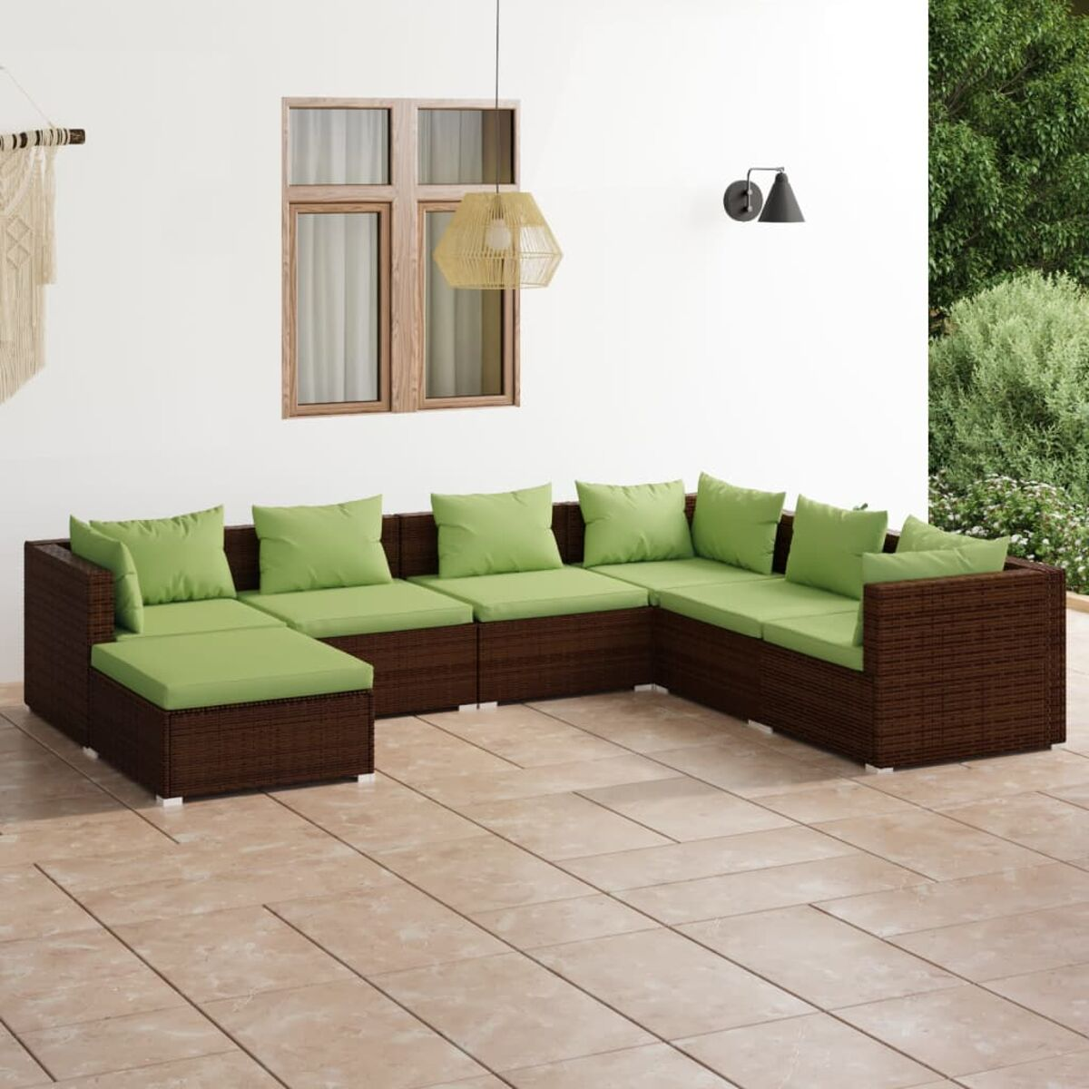 Braune Rattan-Außensitzgruppe mit grünen Kissen.