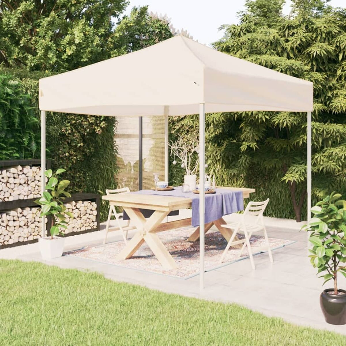 Eine Hinterhofszene mit weißem Zelt, Tisch, Stühlen und Garten.