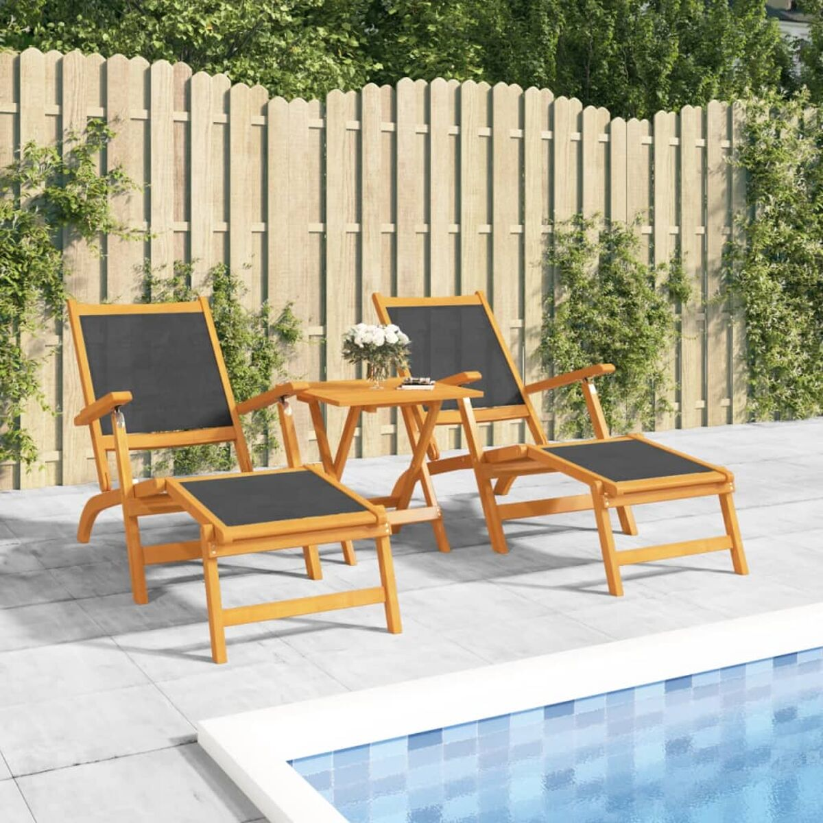 Gartenstühle, Fußstützen und ein kleiner Tisch am Pool. Holzmöbel, schwarze Kissen, sonnig.