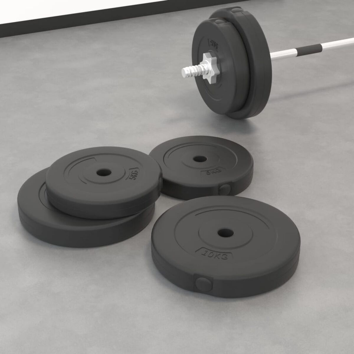 Schwarze Gewichtsplatten mit 5kg und 10kg Beschriftung und eine Langhantel. Gewichte auf grauem Betonboden.