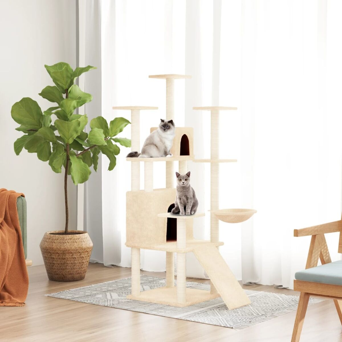 Ein Kratzbaum mit zwei Katzen in einem Wohnzimmer. Eine Katze oben, die andere im Versteck. Gemütliche Atmosphäre.
