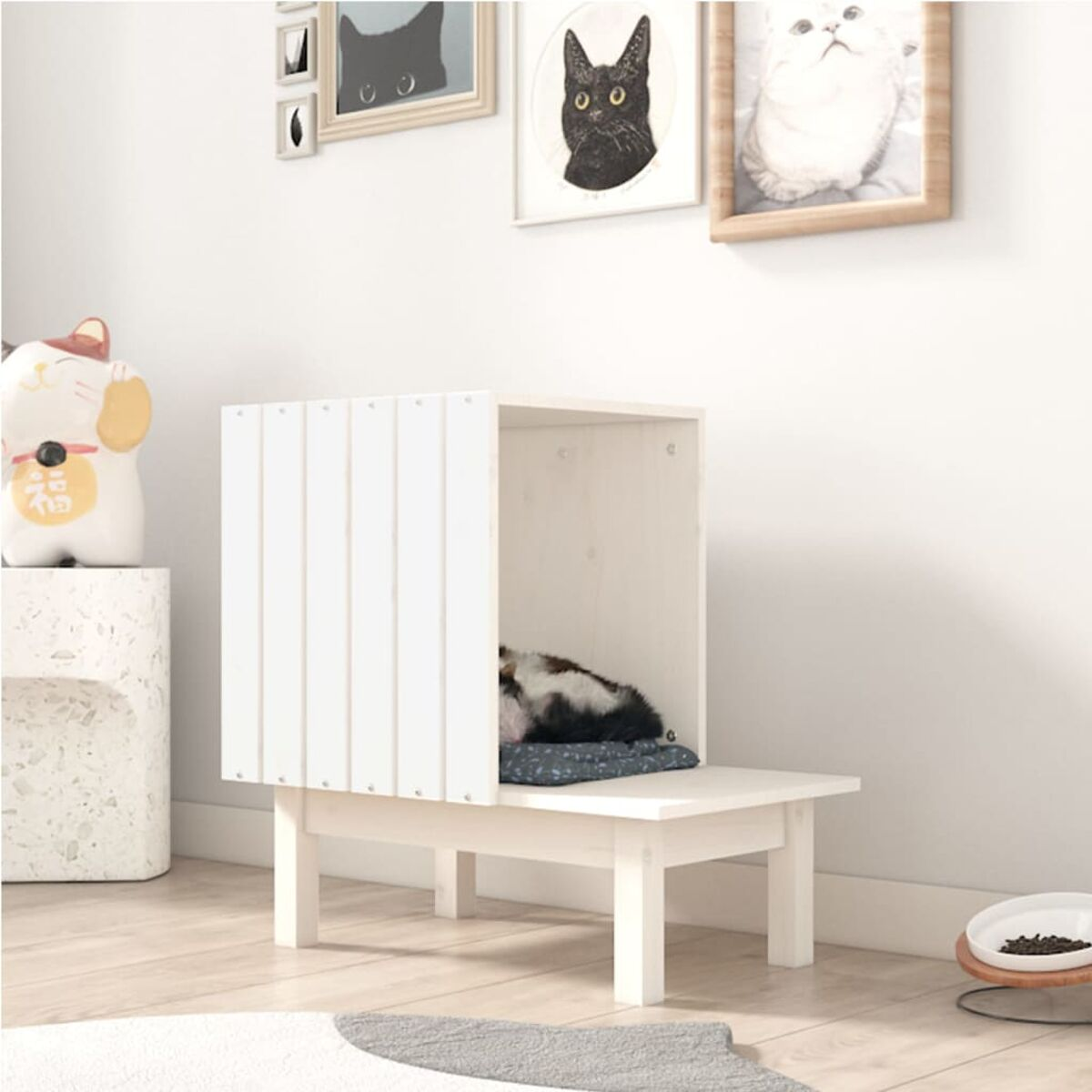 Ein weißes Katzenbett mit Katze darin, umgeben von Katzen-Dekoration.