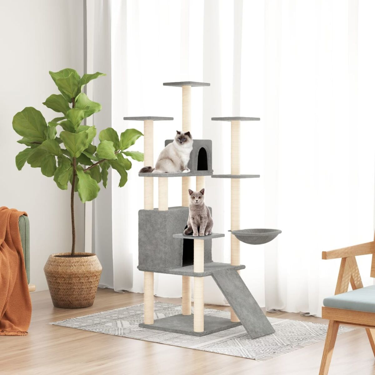 Katzenbaum mit zwei Katzen, Pflanzen und Dekoration in einem Raum.