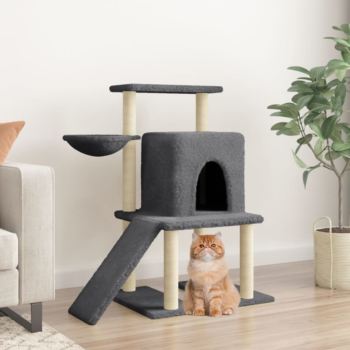 Ein Katzenbaum mit einer Katze davor, vor einer Wand mit einer Pflanze.