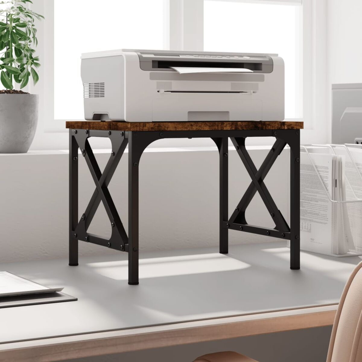 Ein weißer Drucker auf einem braunen und schwarzen Schreibtisch. Der Schreibtisch hat ein X-förmiges Gestell.
