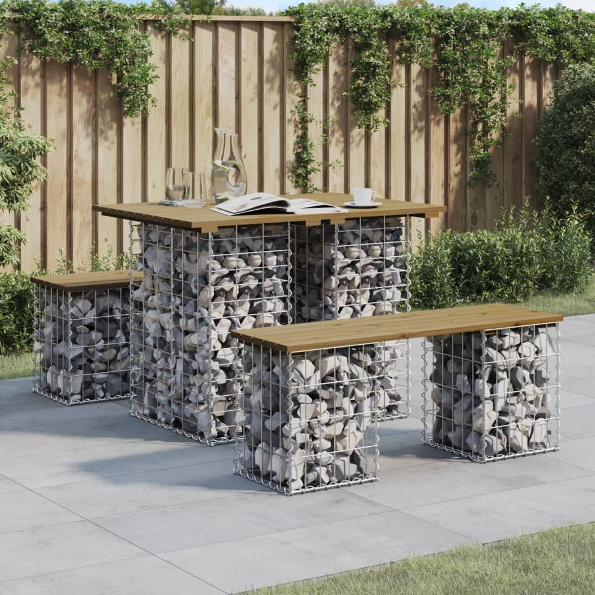 Ein Terrassenset: Holztisch und -bänke mit steinbefüllten Gabionenbasen auf einer gepflasterten Fläche.
