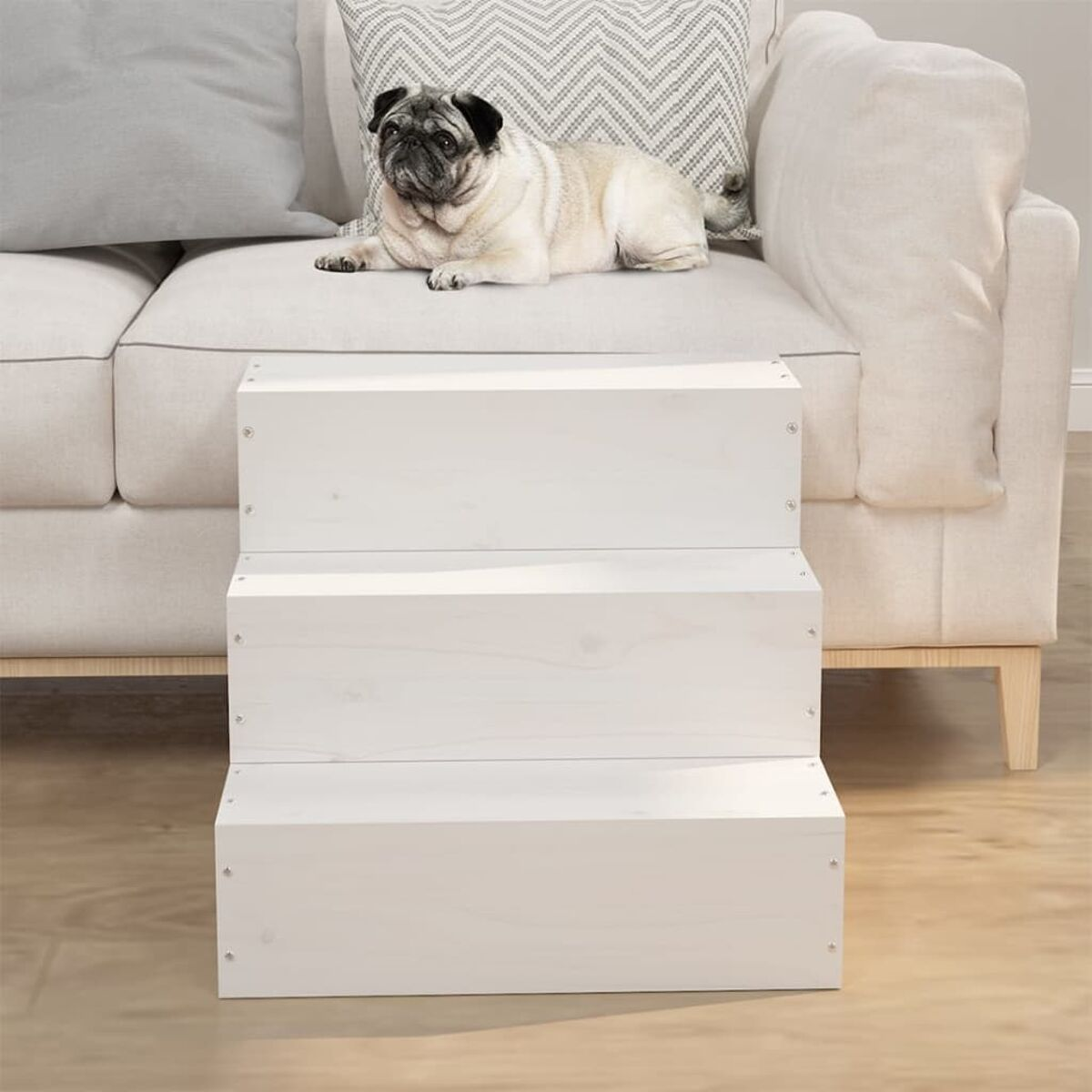 Ein Mops auf einem Sofa, mit weißen Holz-Haustier-Treppen.