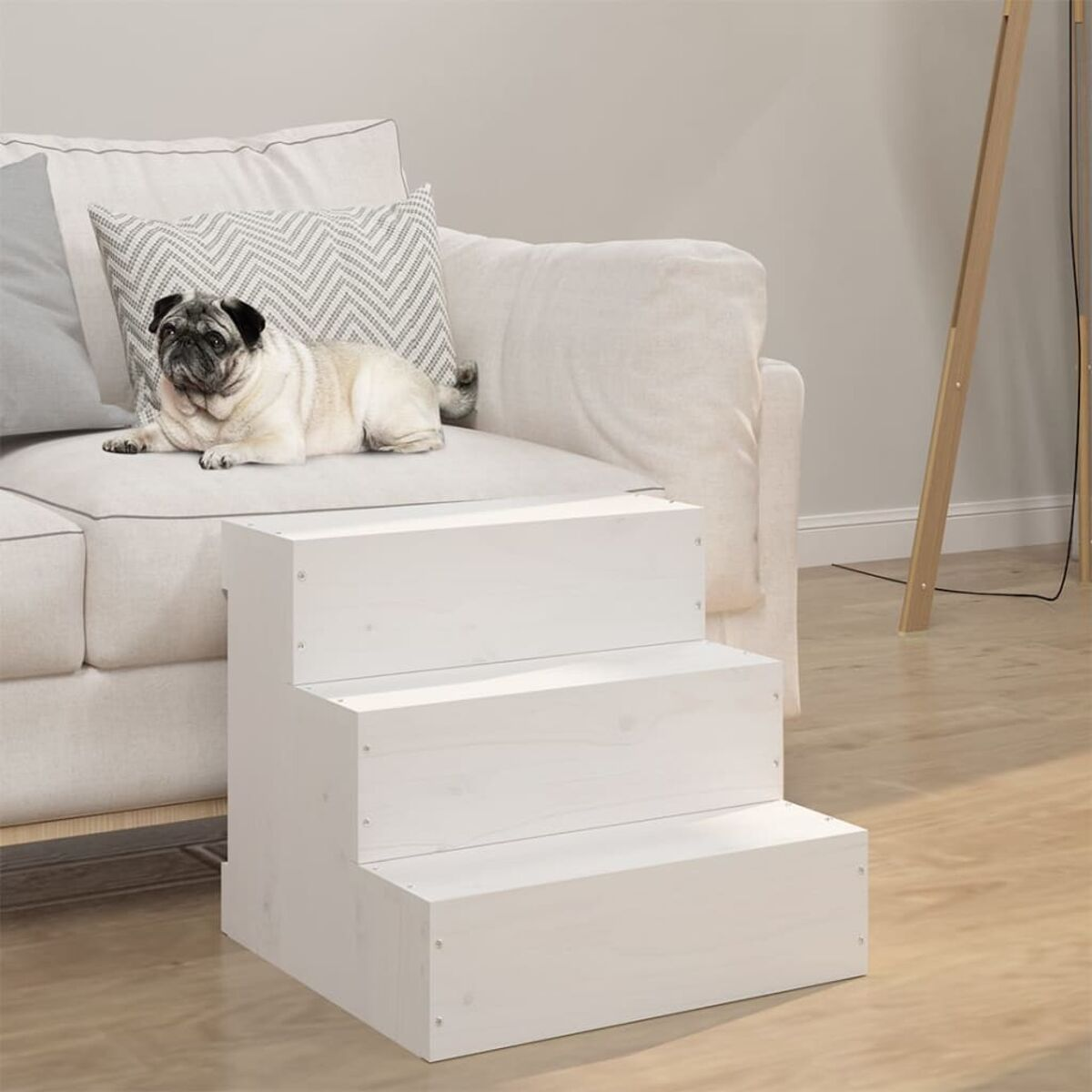 Weiße Haustier-Treppe aus Holz. Ein Mops liegt auf einer weißen Couch im Hintergrund.