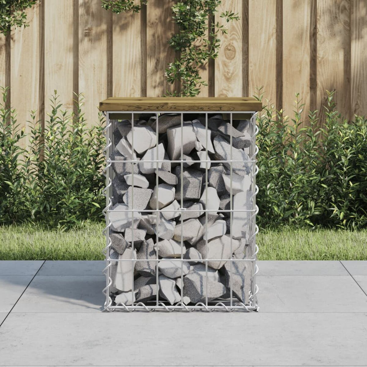 Gabion mit Steinen gefüllt. Holzplatte. Auf einer Terrasse, umgeben von Gras.