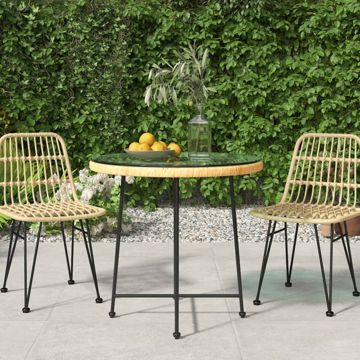Rattan-Tisch und Stühle auf Terrasse mit grünem Heckenhintergrund.