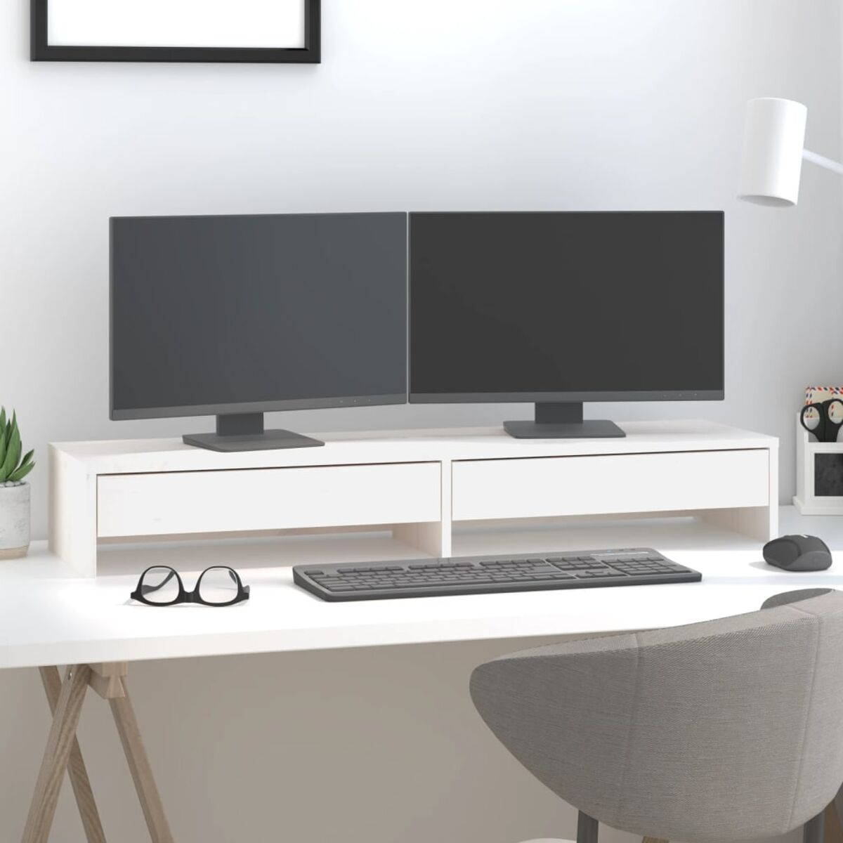 Ein weißer Schreibtisch mit zwei Monitoren, Tastatur, Maus, Brille und Pflanze.