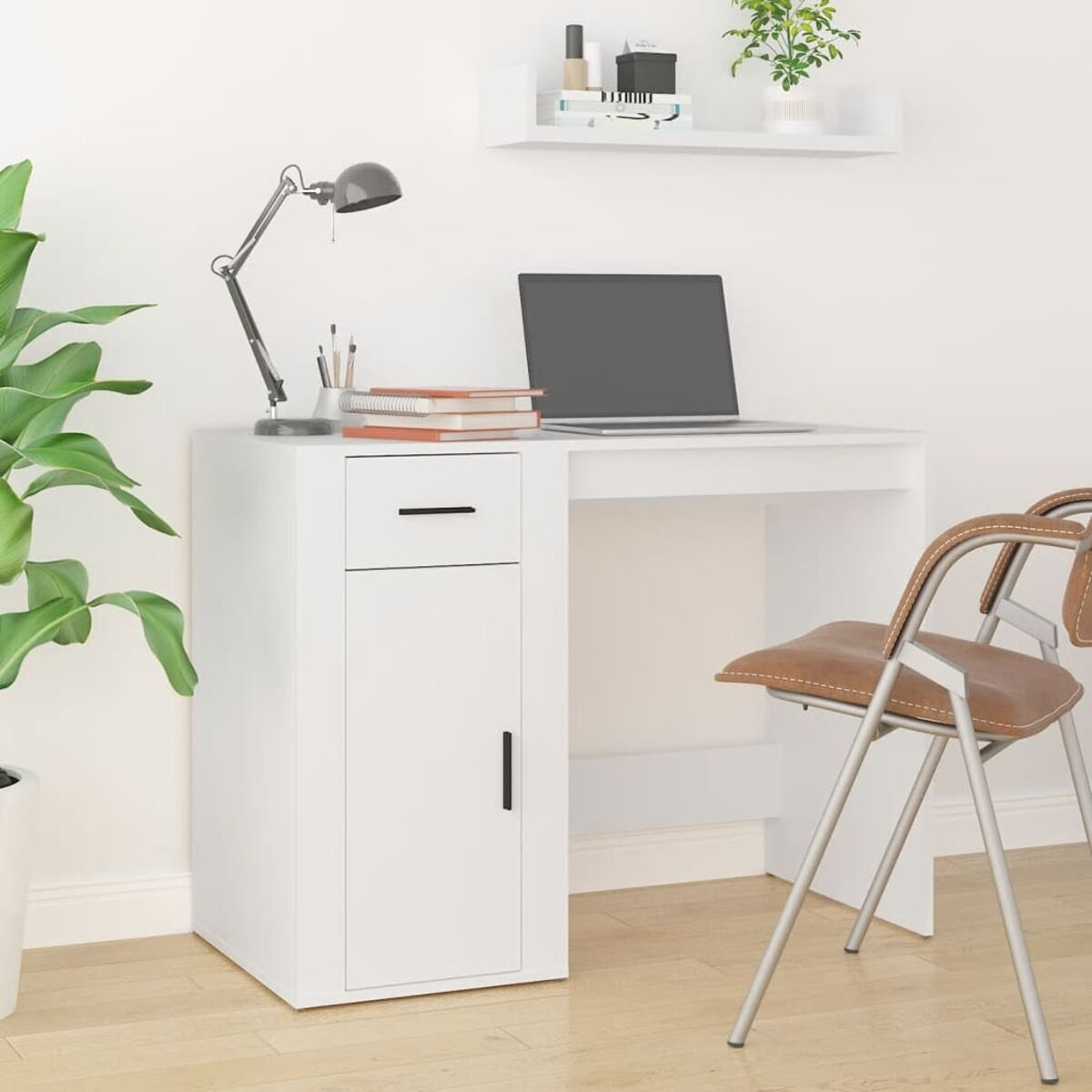 Weißer Schreibtisch mit Laptop, Lampe und Stuhl. Bücher und Pflanze auf dem Schreibtisch, Regal darüber. Brauner Stuhl.