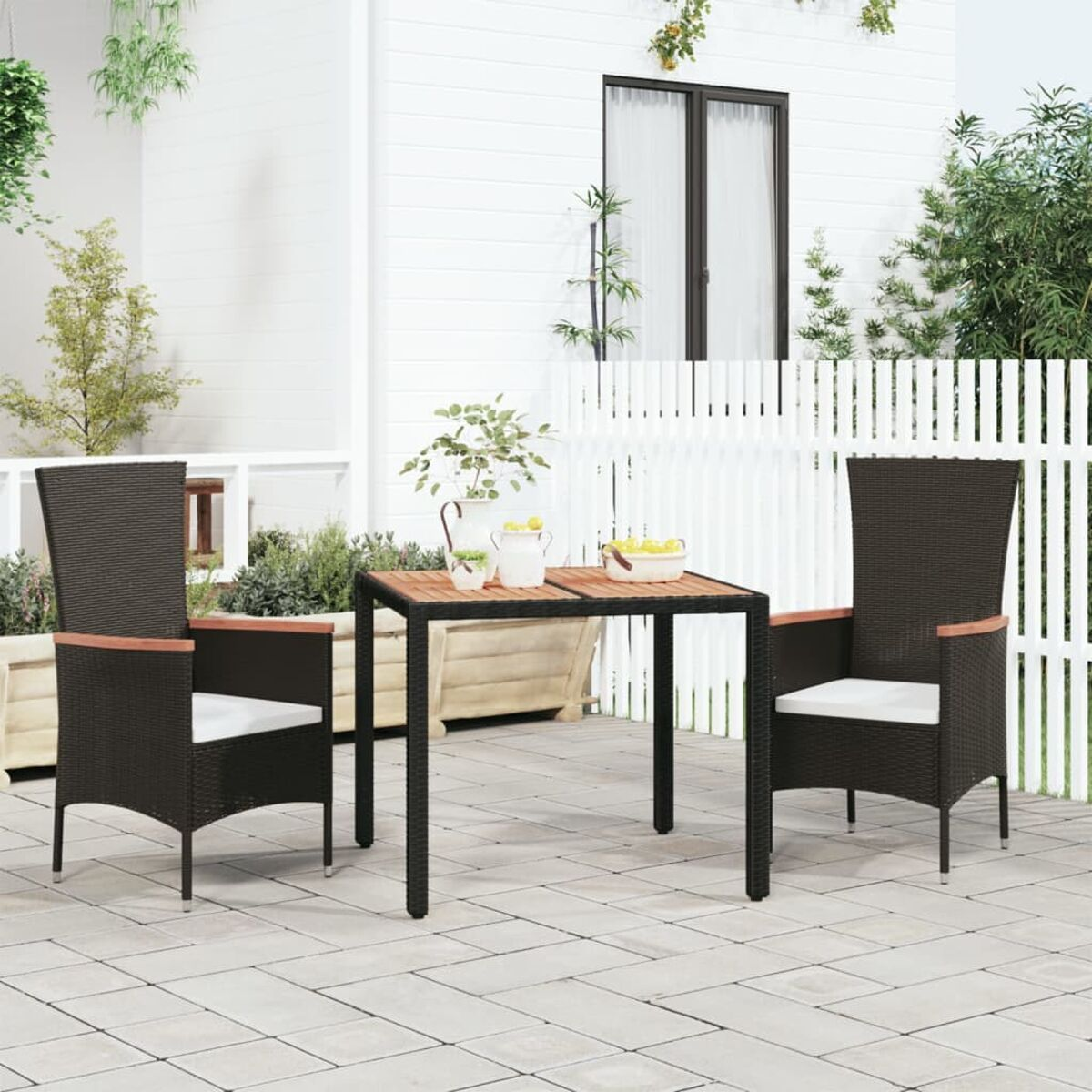 Essgruppe für draußen mit zwei Stühlen und einem Tisch. Stühle sind schwarz und haben weiße Kissen.