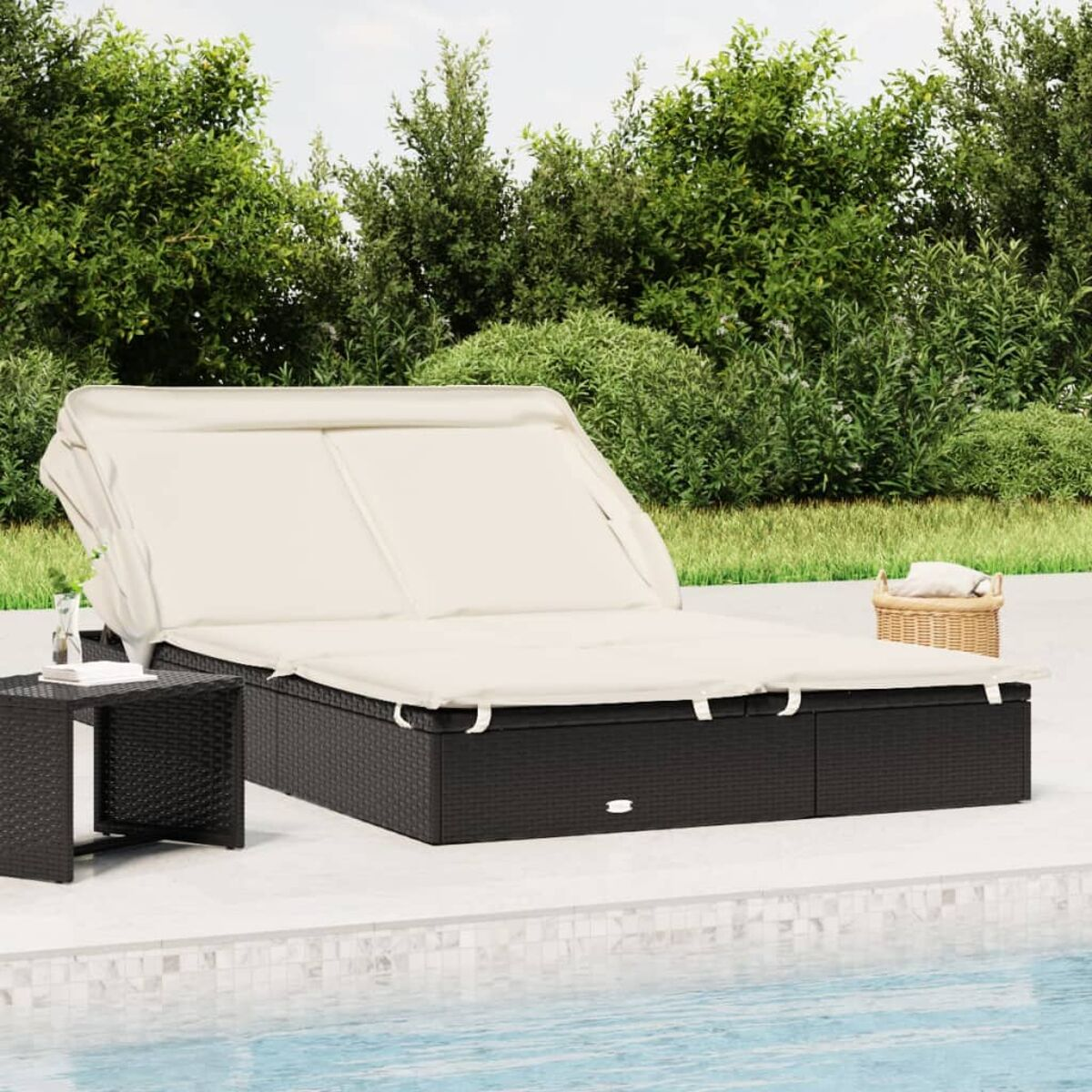 Eine schwarze und beige Chaiselongue mit einem Beistelltisch und einem Korb am Pool.
