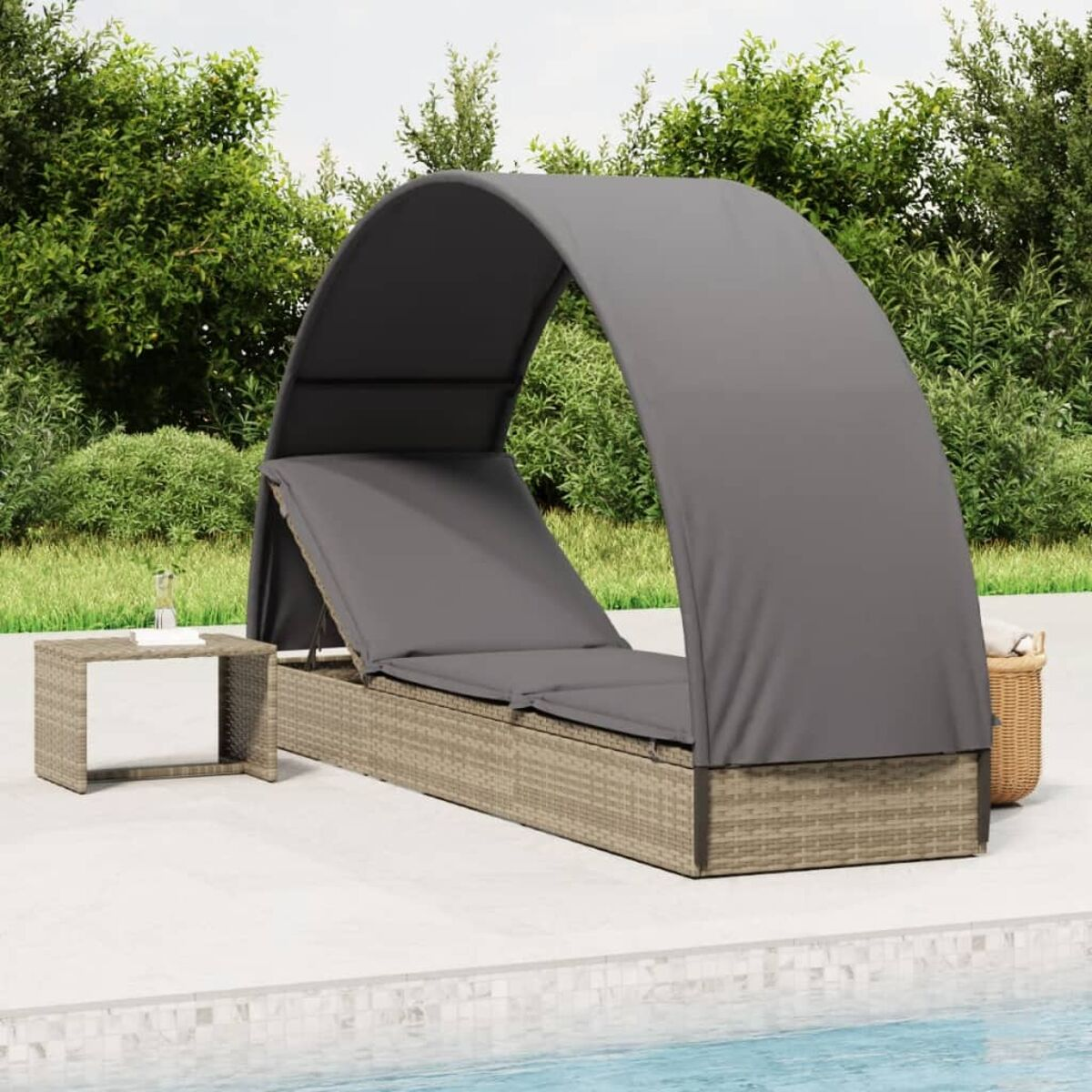 Graues Daybed mit Baldachin neben einem Tisch mit Wasserglas.