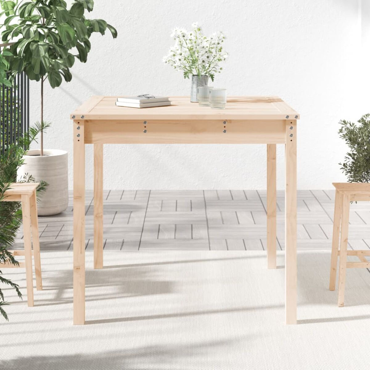 Holztisch-Set für draußen. Quadratischer Tisch, helles Holz, mit Gläsern und einem Buch.